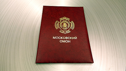 Папка с мягкими корочками в красном переплете выполнена на заказ от московского ОМОН в типографии Арт Полиграфия, золотое тиснение папки гербом